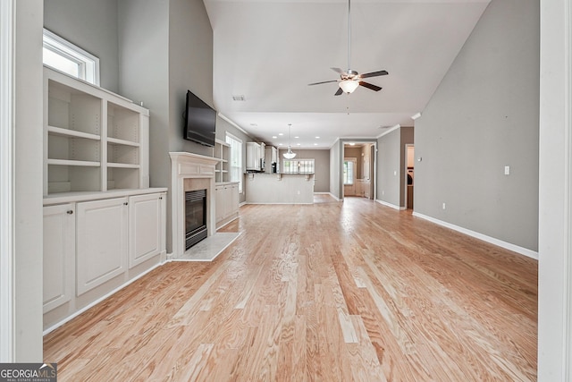 6722 Blue Heron Way, Flowery Branch, GA 30542 - unfurnished living room featuring ceiling fan, a glass covered fireplace, light wood finished floors, and lofted ceiling