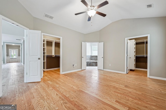 6722 Blue Heron Way, Flowery Branch, GA 30542 - unfurnished bedroom with a walk in closet, a closet, lofted ceiling, and light wood-type flooring