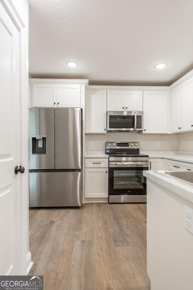 1920 Darling Ave, Waycross, GA 31501 - kitchen with appliances with stainless steel finishes, light countertops, white cabinets, recessed lighting, and a textured ceiling