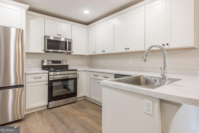 1920 Darling Ave, Waycross, GA 31501 - kitchen featuring appliances with stainless steel finishes, light wood-type flooring, white cabinets, light countertops, and recessed lighting