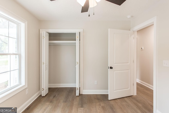 1920 Darling Ave, Waycross, GA 31501 - unfurnished bedroom featuring wood finished floors, multiple windows, a closet, and ceiling fan