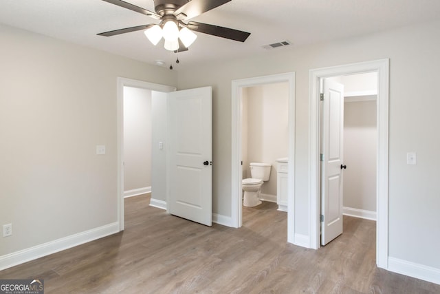 1920 Darling Ave, Waycross, GA 31501 - unfurnished bedroom with wood finished floors, a spacious closet, ensuite bath, and a ceiling fan
