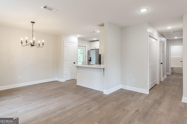 1920 Darling Ave, Waycross, GA 31501 - unfurnished living room with light wood-style flooring, a chandelier, and recessed lighting