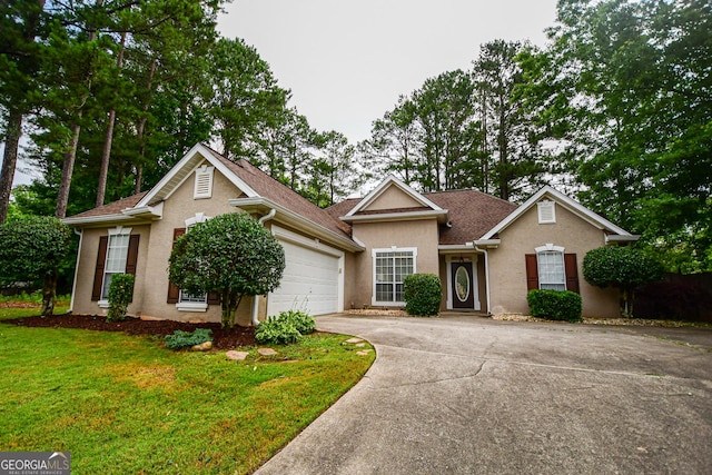 17 Kingsbrook Ln, Newnan, GA 30265 - view of front of property with concrete driveway, an attached garage, stucco siding, and a front lawn