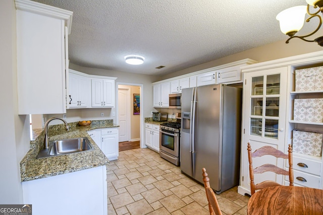 17 Kingsbrook Ln, Newnan, GA 30265 - kitchen with stainless steel appliances, white cabinets, light stone counters, and a textured ceiling