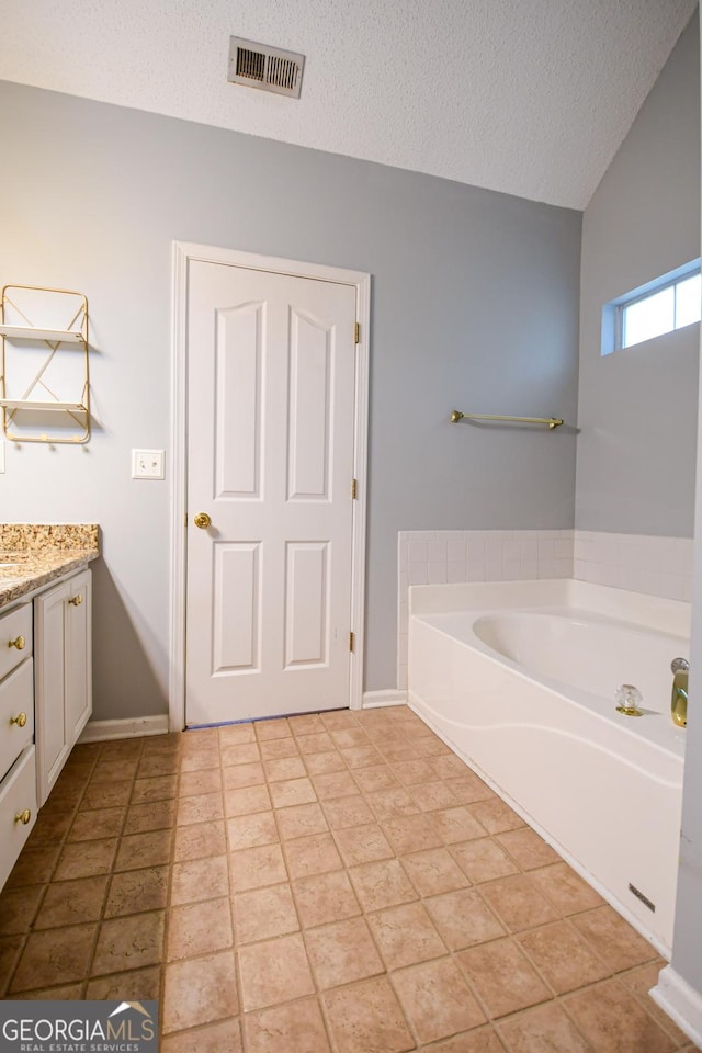 17 Kingsbrook Ln, Newnan, GA 30265 - bathroom featuring vanity, a bath, a textured ceiling, and vaulted ceiling