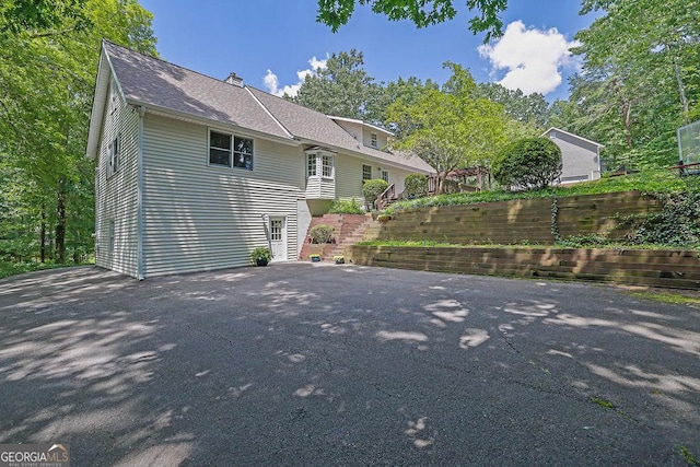 2095 Honeysuckle Dr, Cumming, GA 30040 - rear view of property featuring a shingled roof and driveway