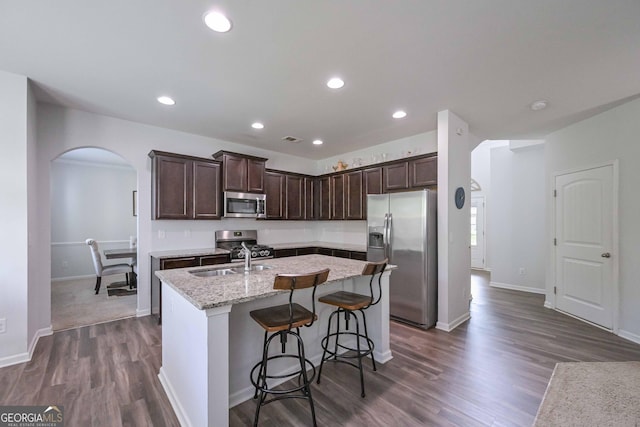 110 Serendipity Way, Dallas, GA 30157 - kitchen featuring stainless steel appliances, arched walkways, dark brown cabinets, a kitchen island with sink, and dark wood-style flooring