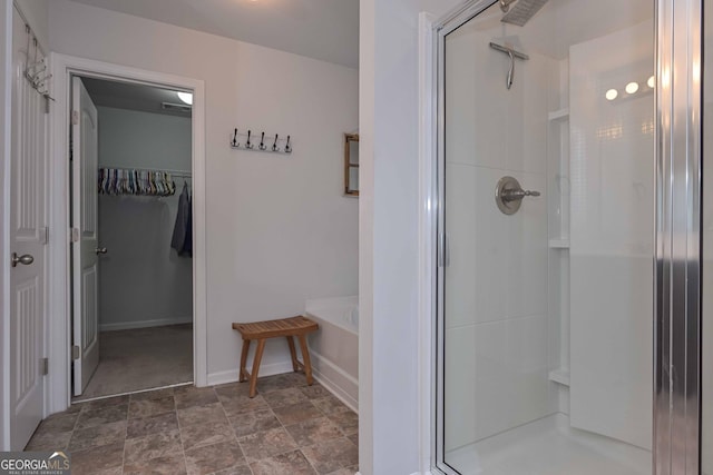 110 Serendipity Way, Dallas, GA 30157 - bathroom featuring a stall shower, a walk in closet, a bath, and stone finish floors