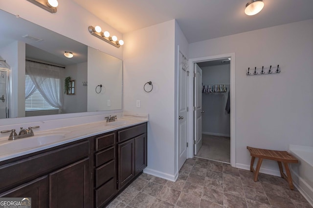 110 Serendipity Way, Dallas, GA 30157 - bathroom with double vanity, a spacious closet, stone finish floors, and a shower with door