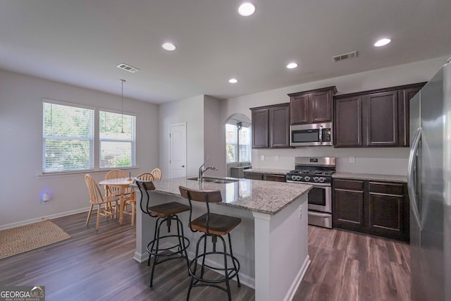 110 Serendipity Way, Dallas, GA 30157 - kitchen featuring appliances with stainless steel finishes, light stone counters, dark wood finished floors, a center island with sink, and recessed lighting