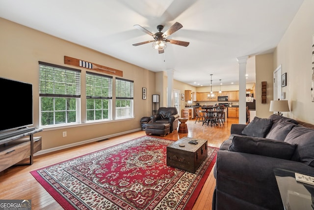 6521 Boulder Crest Ct, Flowery Branch, GA 30542 - living room with ornate columns, healthy amount of natural light, ceiling fan, and light wood-style flooring