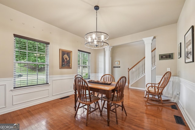 6521 Boulder Crest Ct, Flowery Branch, GA 30542 - dining space featuring a chandelier, wood finished floors, wainscoting, stairway, and a decorative wall
