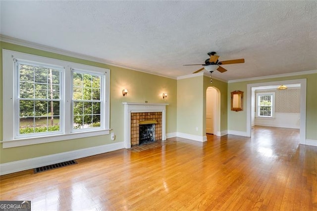 303 Hardee St, Dallas, GA 30132 - unfurnished living room featuring wood finished floors, a ceiling fan, a textured ceiling, arched walkways, and a tile fireplace