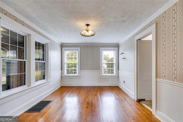 303 Hardee St, Dallas, GA 30132 - unfurnished dining area with wood finished floors, wallpapered walls, a textured ceiling, and ornamental molding