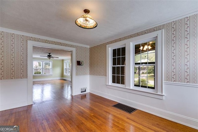 303 Hardee St, Dallas, GA 30132 - unfurnished dining area with wallpapered walls, wood finished floors, a wainscoted wall, ornamental molding, and ceiling fan