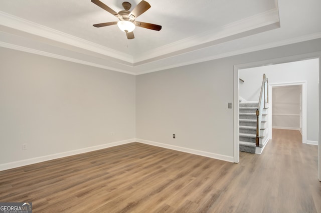 40 Springwater Chase, Newnan, GA 30265 - empty room featuring a raised ceiling, stairs, wood finished floors, ceiling fan, and crown molding