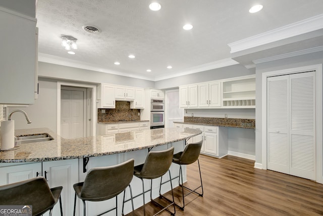 40 Springwater Chase, Newnan, GA 30265 - kitchen with open shelves, double oven, a peninsula, stone countertops, and a kitchen bar