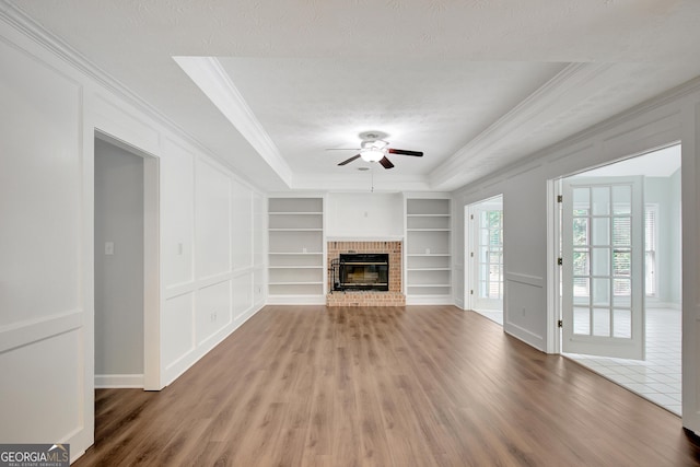 40 Springwater Chase, Newnan, GA 30265 - unfurnished living room with ornamental molding, built in shelves, ceiling fan, wood finished floors, and a fireplace