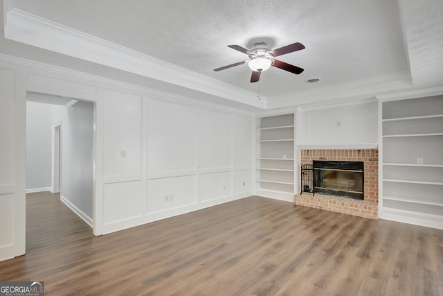 40 Springwater Chase, Newnan, GA 30265 - unfurnished living room with crown molding, ceiling fan, built in shelves, wood finished floors, and a brick fireplace