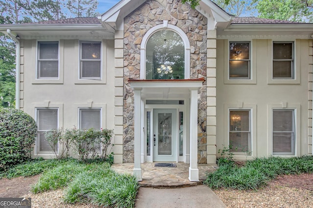 40 Springwater Chase, Newnan, GA 30265 - view of exterior entry with stone siding, roof with shingles, and stucco siding