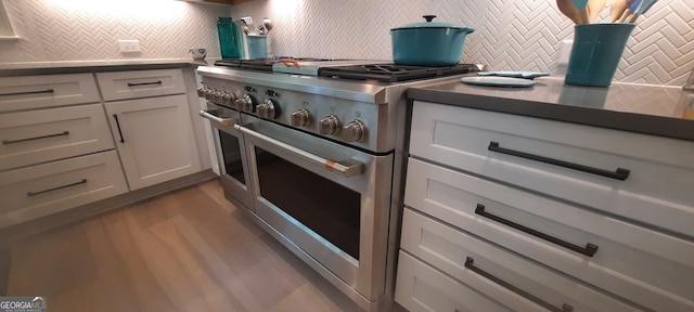 1330 Jackson Ridge Rd, Greensboro, GA 30642 - kitchen featuring range with two ovens, decorative backsplash, wood finished floors, and white cabinetry