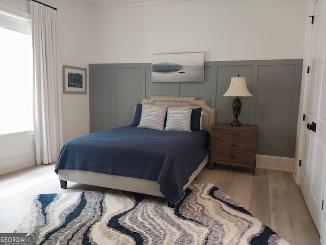 1330 Jackson Ridge Rd, Greensboro, GA 30642 - bedroom with a decorative wall, light wood-style floors, and wainscoting
