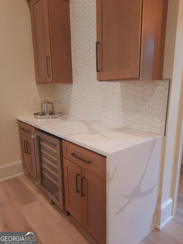 1330 Jackson Ridge Rd, Greensboro, GA 30642 - kitchen featuring wine cooler, tasteful backsplash, light stone countertops, and light wood-type flooring
