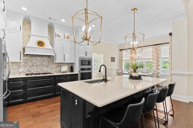 1413 N Walkers Mill Rd, Griffin, GA 30223 - kitchen with a chandelier, dark cabinetry, stainless steel appliances, custom range hood, and crown molding