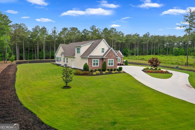 1413 N Walkers Mill Rd, Griffin, GA 30223 - view of front of home featuring curved driveway, a front lawn, brick siding, and a wooded view