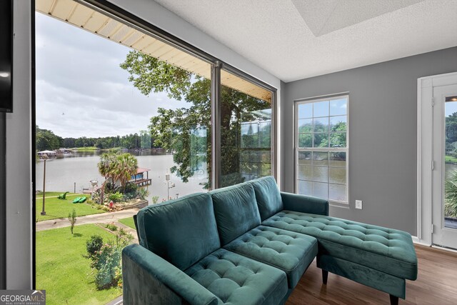 106 Oak Ln, Eatonton, GA 31024 - sitting room with a water view, wood finished floors, healthy amount of natural light, and a textured ceiling