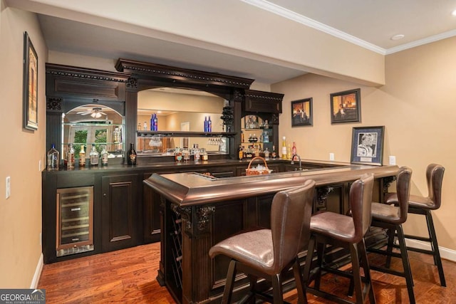287 Scenic Falls Blvd, Hoschton, GA 30548 - indoor wet bar with beverage cooler, crown molding, and wood finished floors