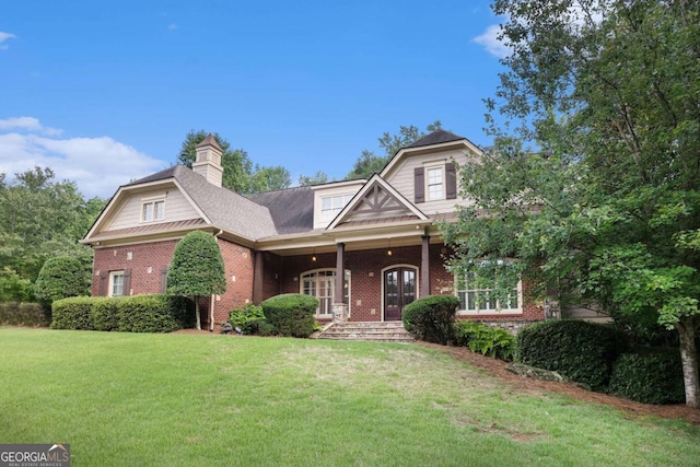 287 Scenic Falls Blvd, Hoschton, GA 30548 - view of front of home featuring brick siding, a front lawn, a porch, and a chimney
