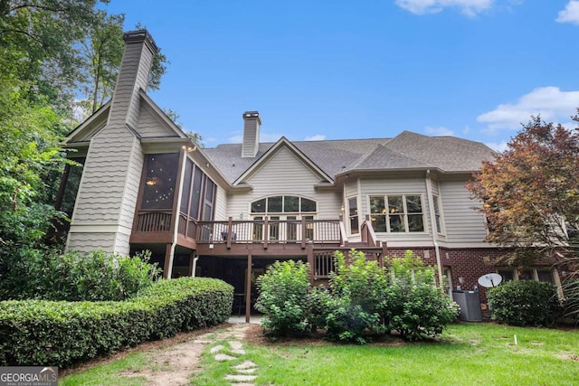 287 Scenic Falls Blvd, Hoschton, GA 30548 - rear view of house with a chimney, a sunroom, a deck, a yard, and brick siding