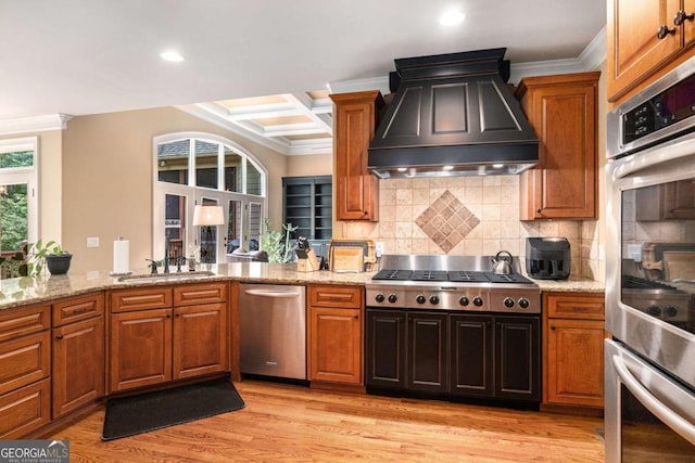 287 Scenic Falls Blvd, Hoschton, GA 30548 - kitchen with stainless steel appliances, custom range hood, crown molding, backsplash, and light stone counters