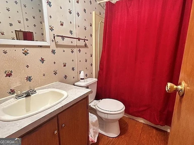 1004 Gordon Ave, Mcrae-Helena, GA 31037 - bathroom with wood finished floors, vanity, curtained shower, and wallpapered walls