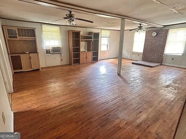 1004 Gordon Ave, Mcrae-Helena, GA 31037 - unfurnished living room featuring a ceiling fan, wood finished floors, cooling unit, and a textured ceiling