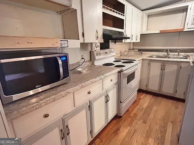 1004 Gordon Ave, Mcrae-Helena, GA 31037 - kitchen featuring white electric range, stainless steel microwave, under cabinet range hood, light wood-type flooring, and white cabinetry