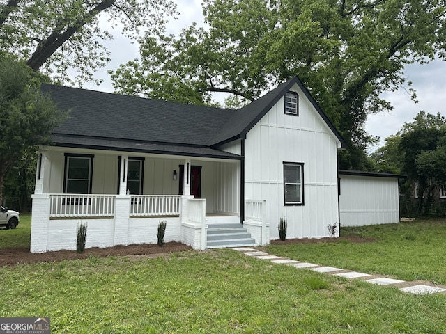 503 S Dooly St, Montezuma, GA 31063 - view of front of house with covered porch, board and batten siding, a front lawn, and roof with shingles