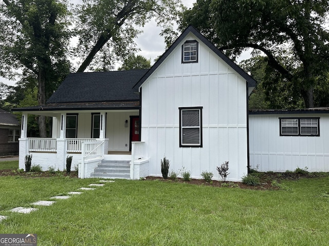 503 S Dooly St, Montezuma, GA 31063 - view of front of home with covered porch, a shingled roof, a front lawn, and board and batten siding