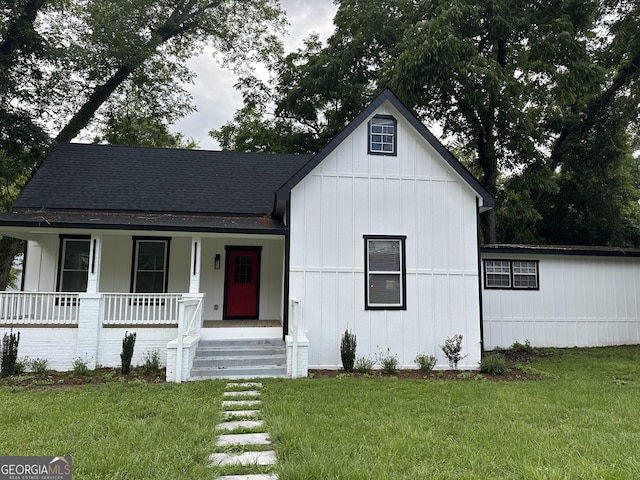 503 S Dooly St, Montezuma, GA 31063 - view of front facade featuring a porch, roof with shingles, a front yard, and board and batten siding