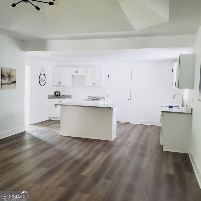 503 S Dooly St, Montezuma, GA 31063 - kitchen with a center island, white cabinetry, dark wood-style floors, and light stone countertops