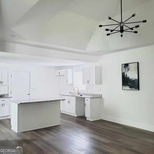 503 S Dooly St, Montezuma, GA 31063 - kitchen with dark wood finished floors, white cabinetry, a kitchen island, a chandelier, and light stone counters