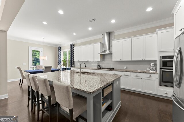 4130 Millbrook Ct, Suwanee, GA 30024 - kitchen featuring wall chimney exhaust hood, dark wood-type flooring, a kitchen island with sink, appliances with stainless steel finishes, and crown molding
