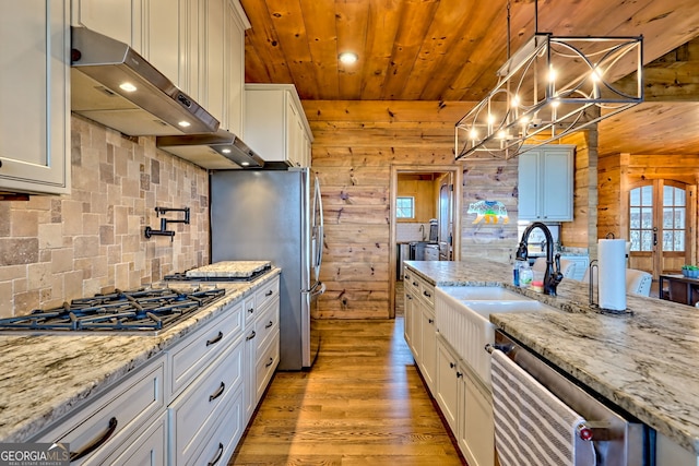899 Ridge Pointe Way, Blairsville, GA 30512 - kitchen with stainless steel appliances, range hood, healthy amount of natural light, wood finished floors, and wood walls