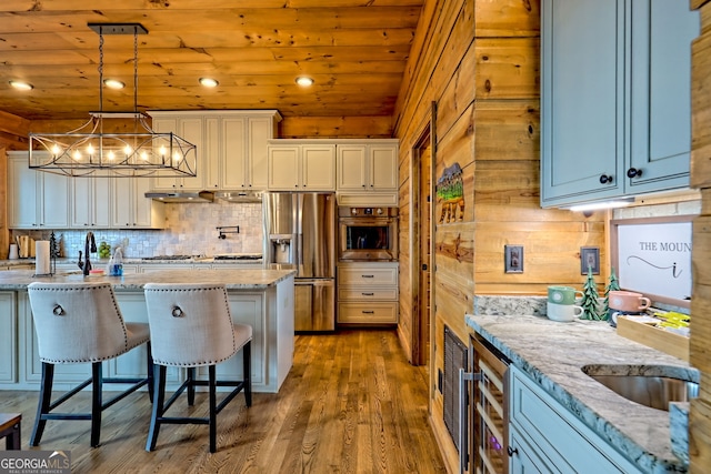 899 Ridge Pointe Way, Blairsville, GA 30512 - kitchen with appliances with stainless steel finishes, a breakfast bar, dark wood-style flooring, light stone counters, and tasteful backsplash