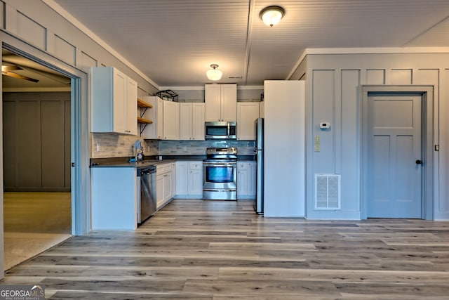 899 Ridge Pointe Way, Blairsville, GA 30512 - kitchen featuring appliances with stainless steel finishes, dark countertops, tasteful backsplash, light wood-type flooring, and white cabinetry