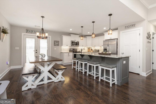 311 Kendall Ct, Perry, GA 31069 - kitchen with stainless steel appliances, white cabinets, recessed lighting, dark wood finished floors, and decorative backsplash