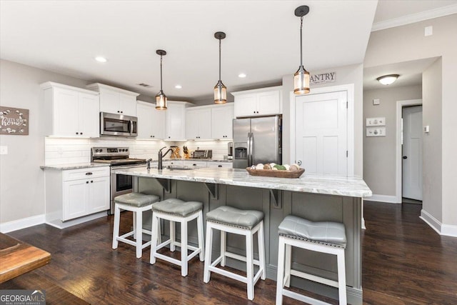 311 Kendall Ct, Perry, GA 31069 - kitchen with stainless steel appliances, white cabinetry, decorative backsplash, dark wood finished floors, and a large island