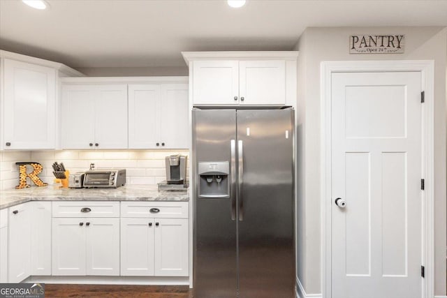 311 Kendall Ct, Perry, GA 31069 - kitchen with stainless steel refrigerator with ice dispenser, white cabinets, light stone counters, decorative backsplash, and recessed lighting